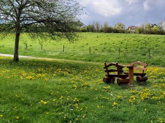 Eine Holzbank mit Tisch lädt zum Verweilen ein am Radweg in Hettenhain.
