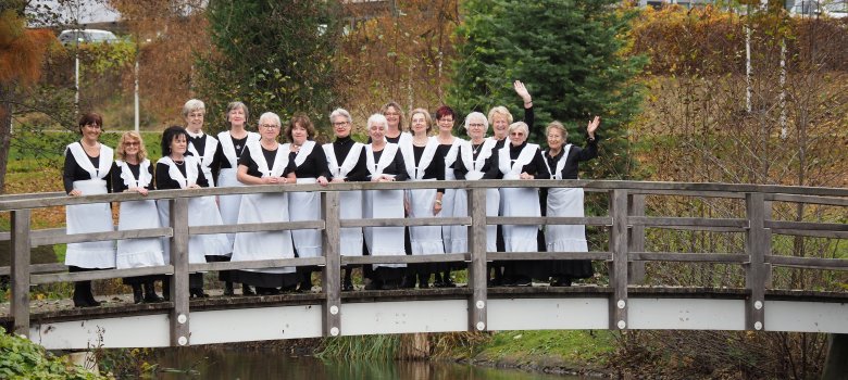 Blick auf die Brunnenfrauen im historischen Gewand auf der Brücke am Kurweiher