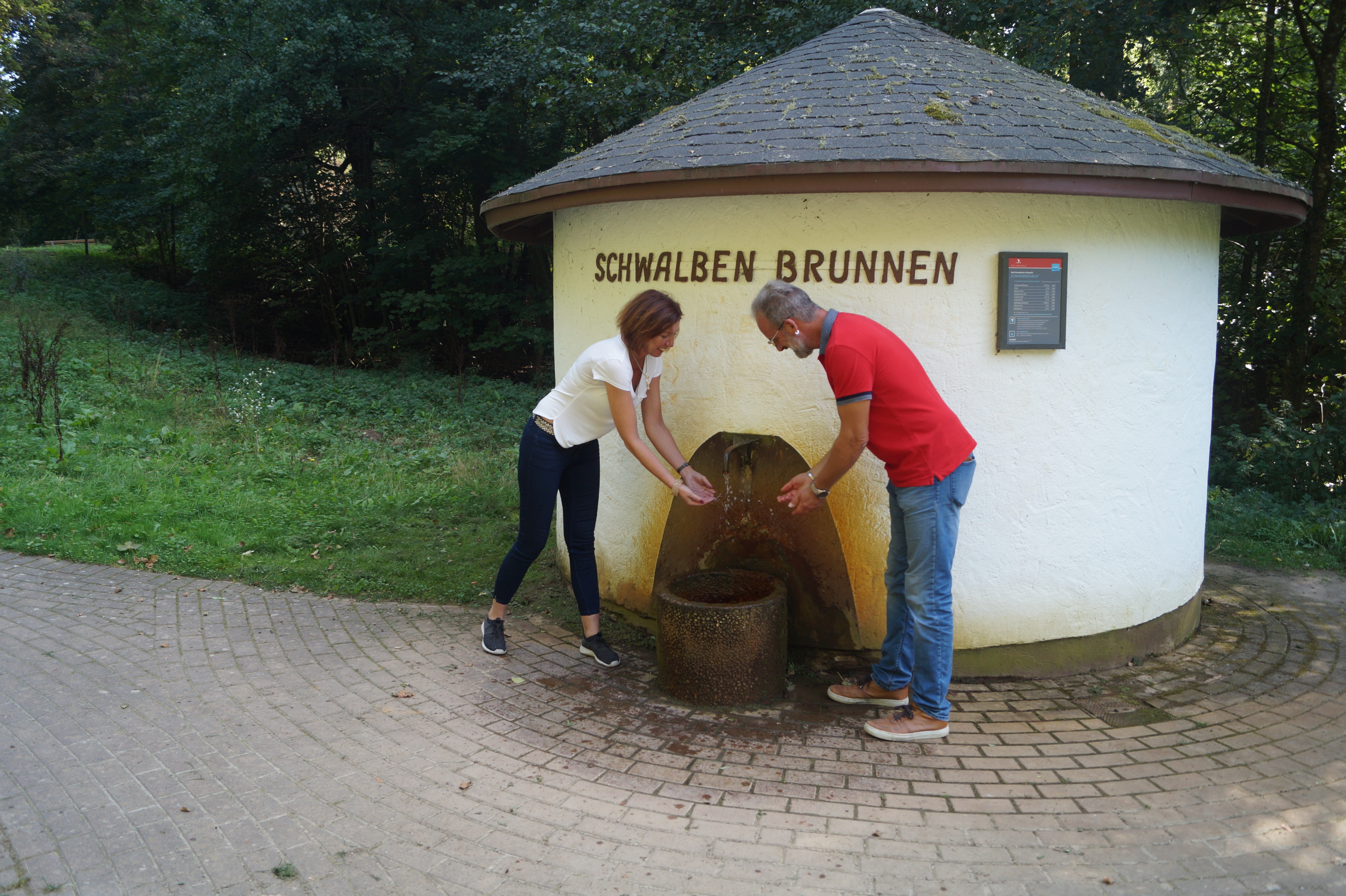 Schwalbenbrunnen Spaziergänger erfrischen sich am Schwalbenbrunnen