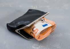 Monetary concept with banknotes in purse on plaster background high angle view. Monetary concept with banknotes in purse on plaster background high angle view.