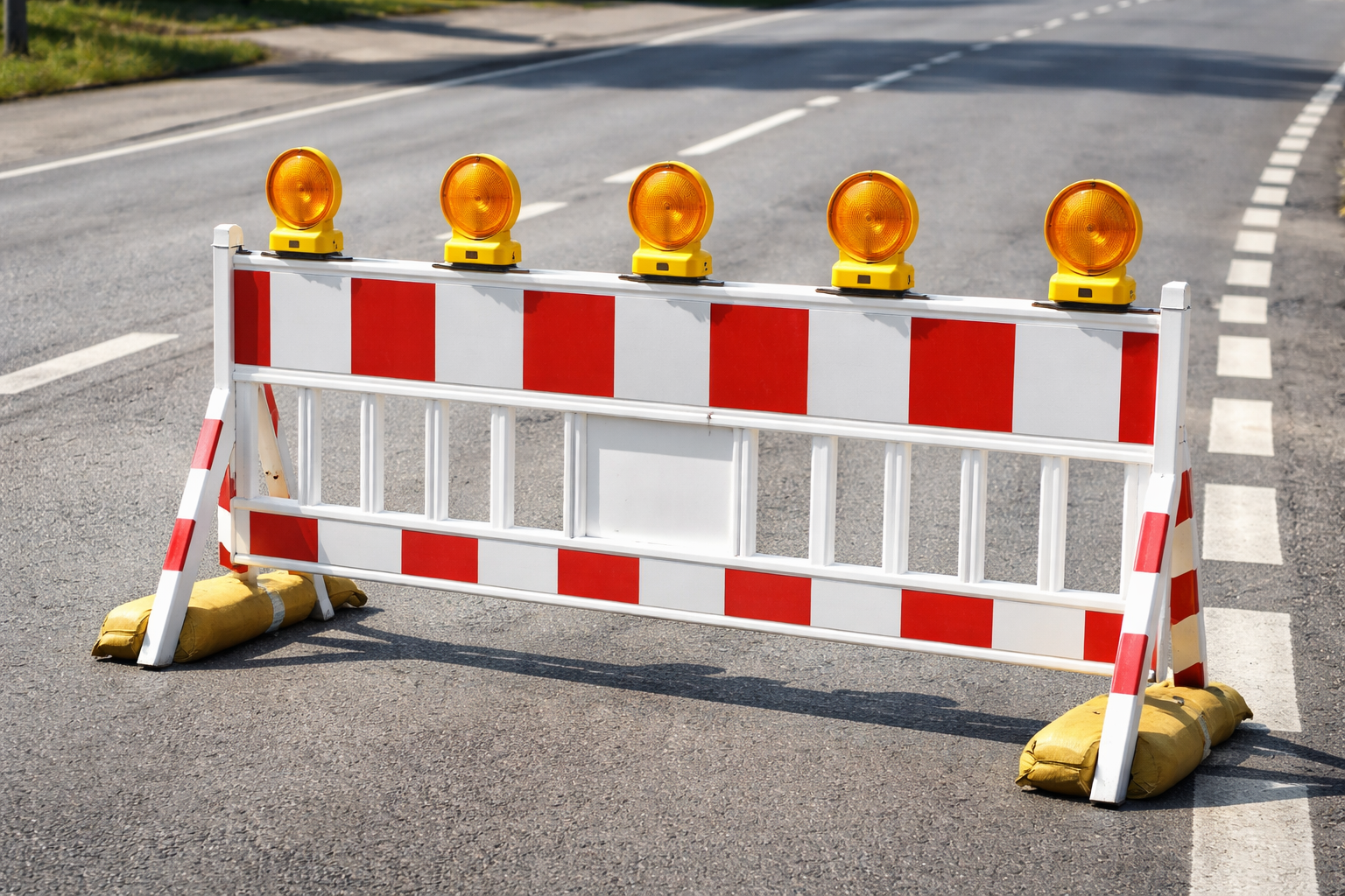 Eine rot-weiße Barriere steht auf einer STraße