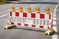 Eine rot-weiße Barriere steht auf einer STraße